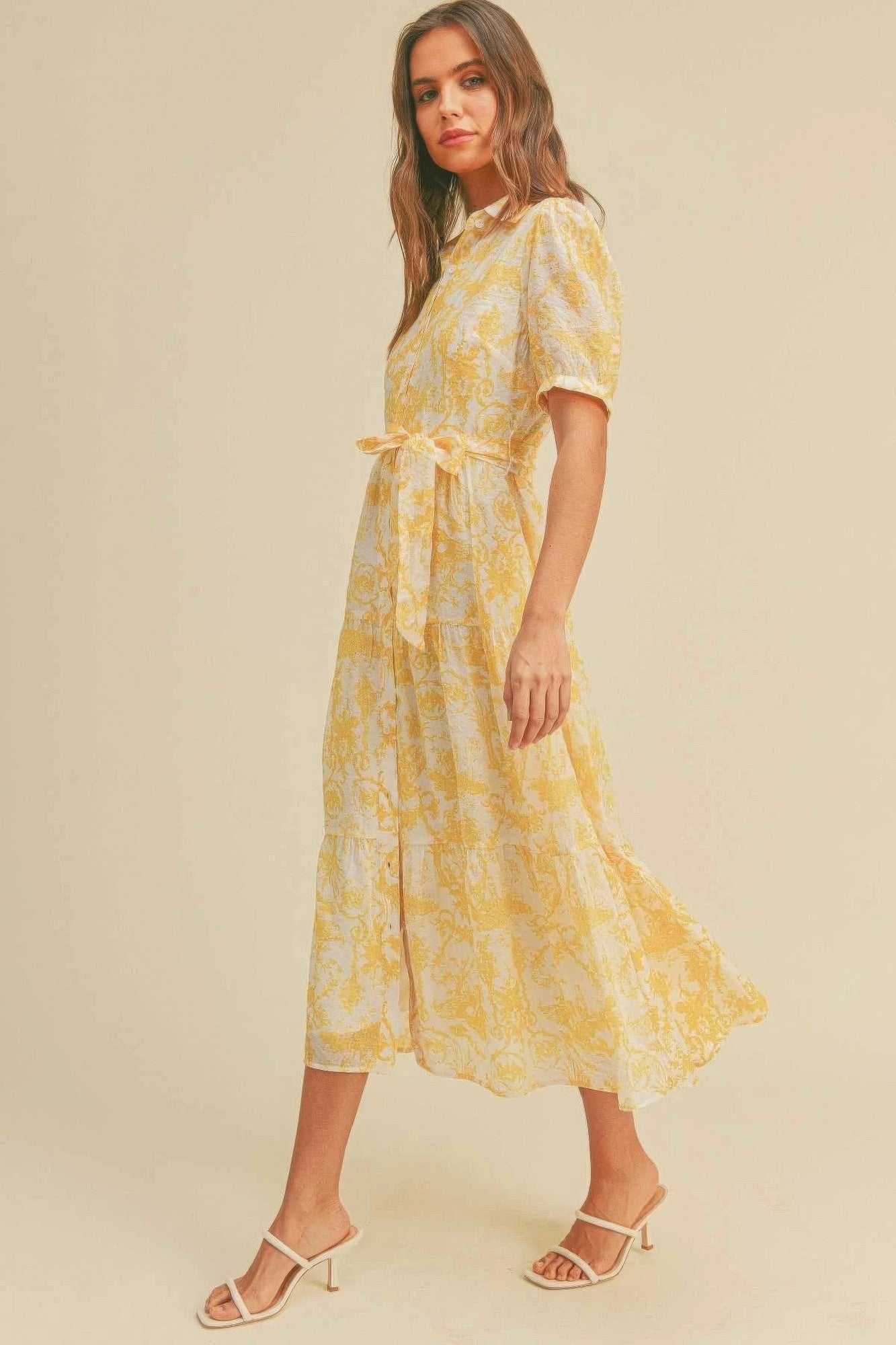 The Harper is our button closure, waist belt and puff sleeve dress. It's made of 95% polyester and 5% spandex, ensuring a comfortable and stretchy fit. The yellow colour palette creates a visually striking and cheerful look. It transitions seamlessly from casual outings to more formal occasions, making it an ideal choice for various events.