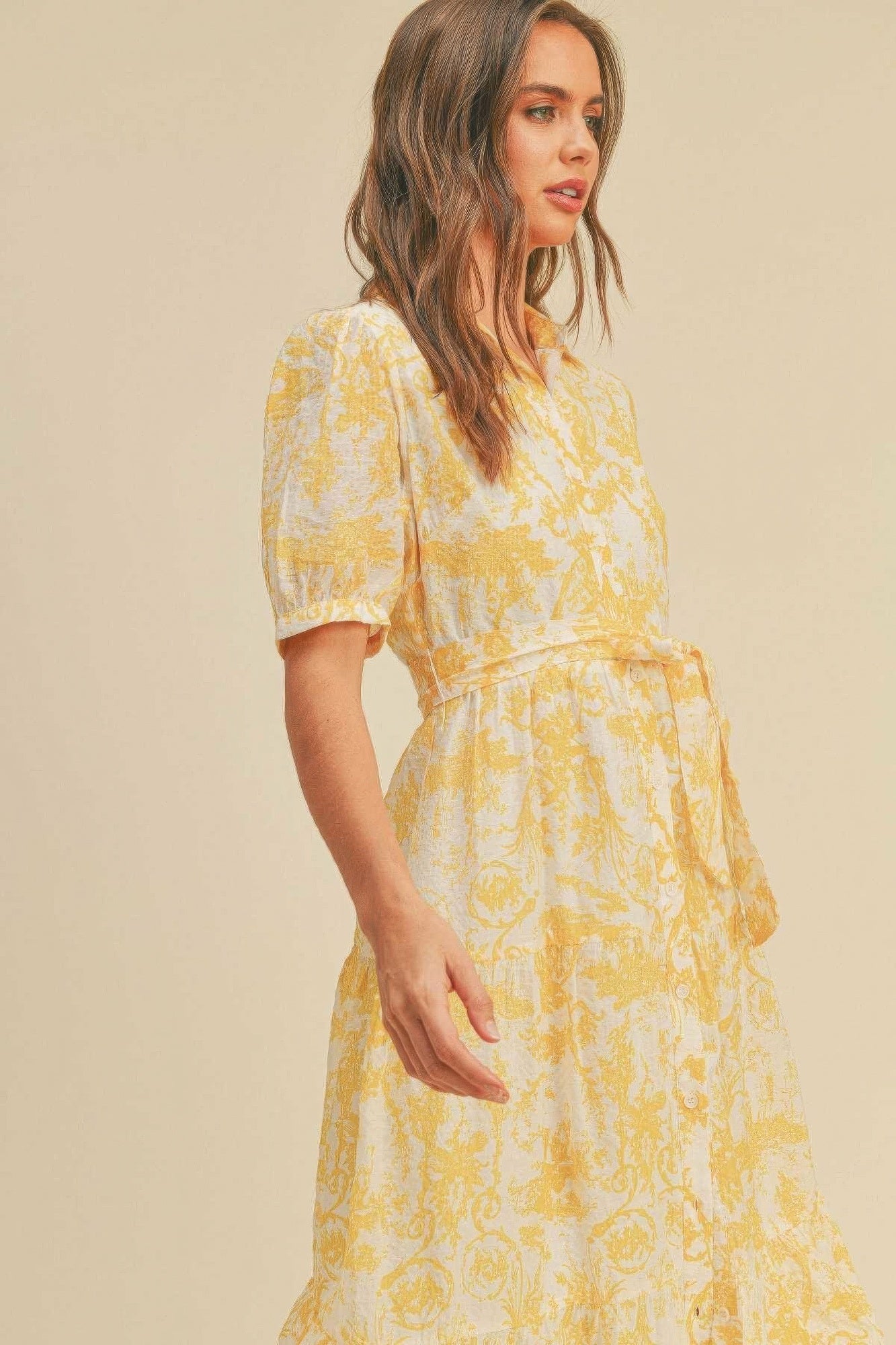 The Harper is our button closure, waist belt and puff sleeve dress. It's made of 95% polyester and 5% spandex, ensuring a comfortable and stretchy fit. The yellow colour palette creates a visually striking and cheerful look. It transitions seamlessly from casual outings to more formal occasions, making it an ideal choice for various events.