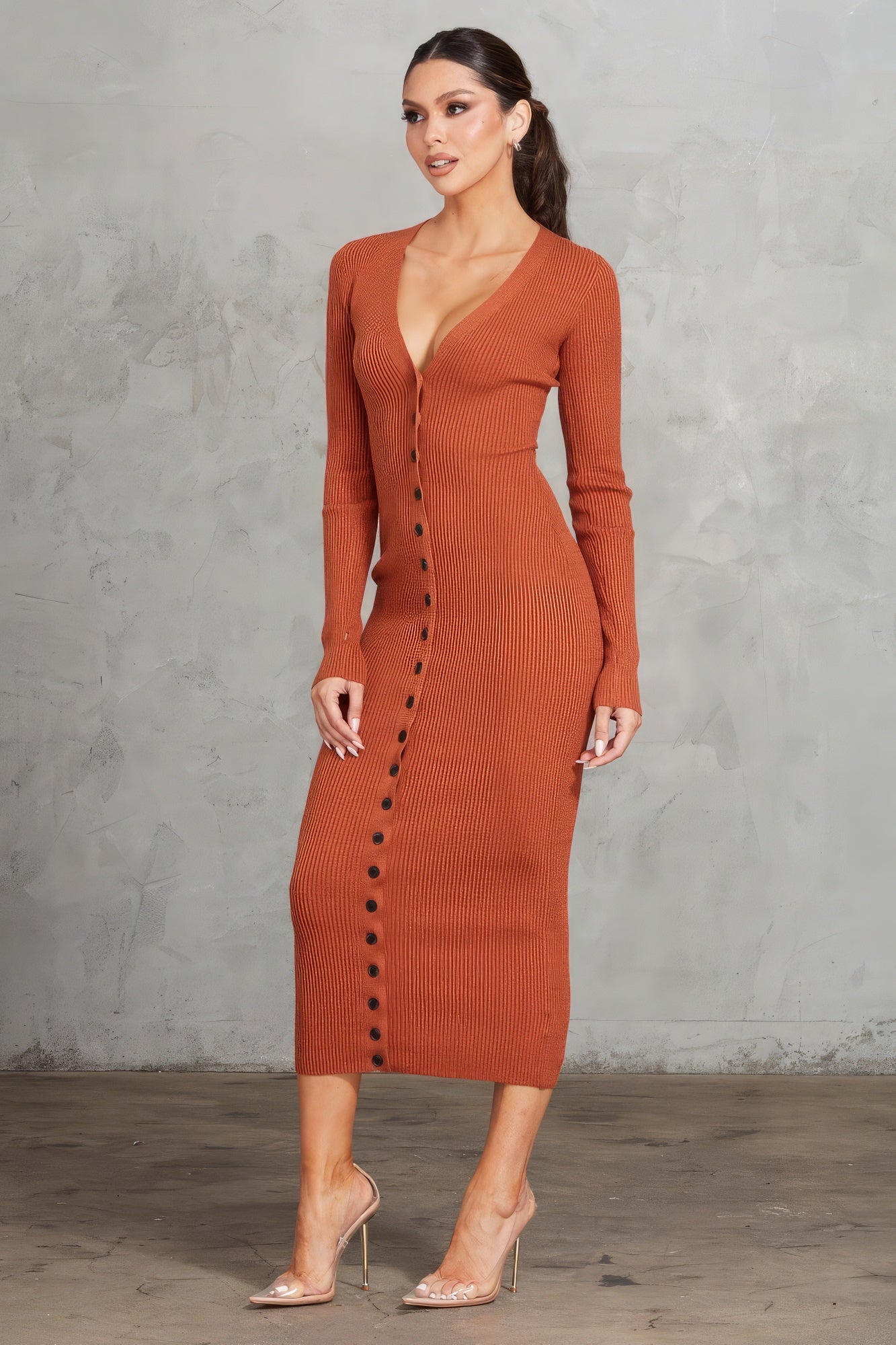Enhance your style with The Nora, a gorgeous cognac bodycon dress. It features a button front, a V-neck, and long sleeves with thumbholes for a chic and contemporary look. Crafted from a premium blend of 43% viscose, 42% polyester, and 15% nylon, this dress offers a perfect combination of comfort and sophistication. Perfect for a night out, special events, or any occasion where you want to showcase your sophisticated style.