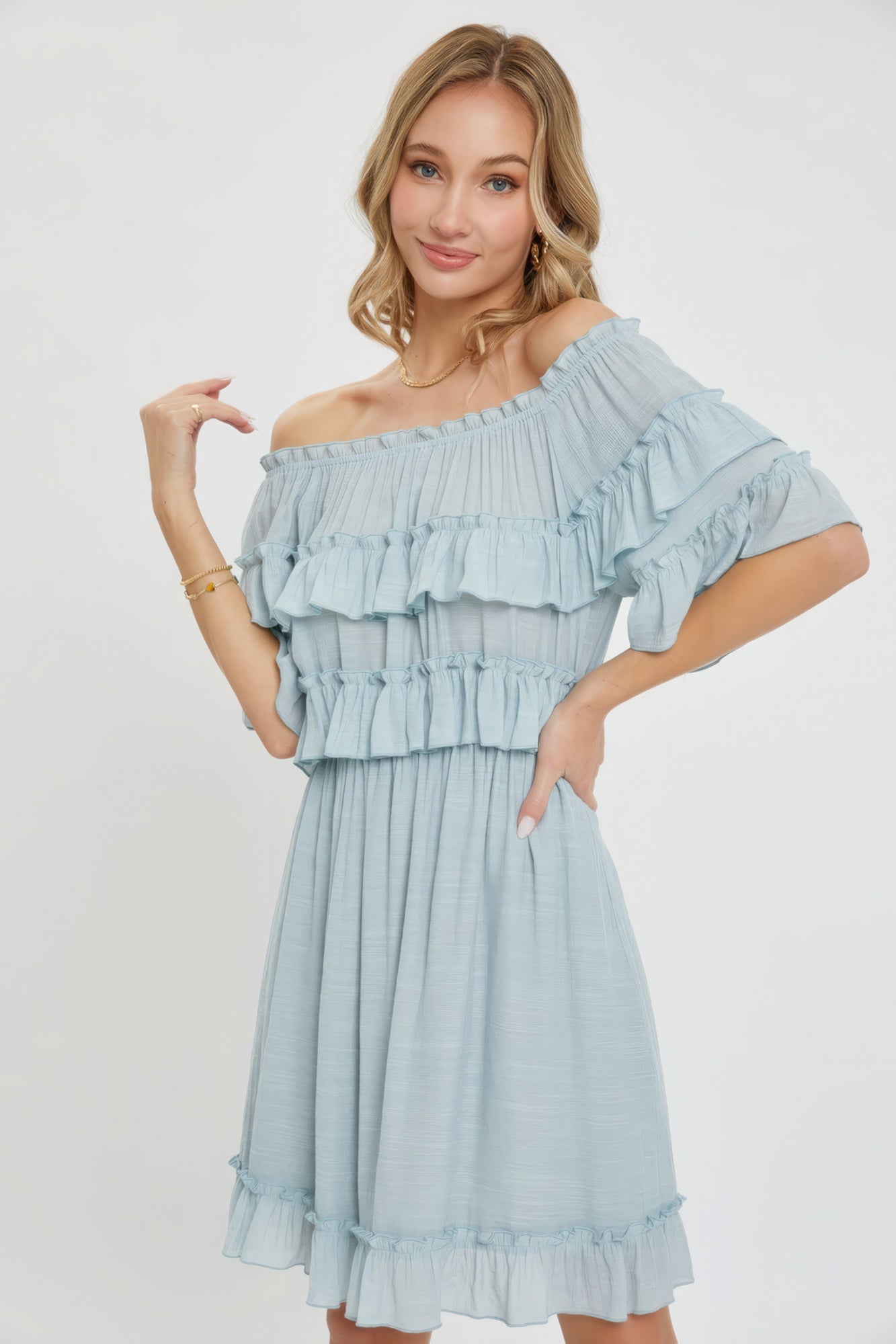 The Kayla is a relaxed-fit, bohemian-style dress that effortlessly combines elegance and comfort. This off-shoulder, short-sleeve dress features an elastic waist, a ruffle bottom, and a feminine silhouette. Crafted from 100% polyester, The Kayla is both soft and lightweight. This misty blue dress is ideal for casual weddings, outdoor gatherings and beach vacations.