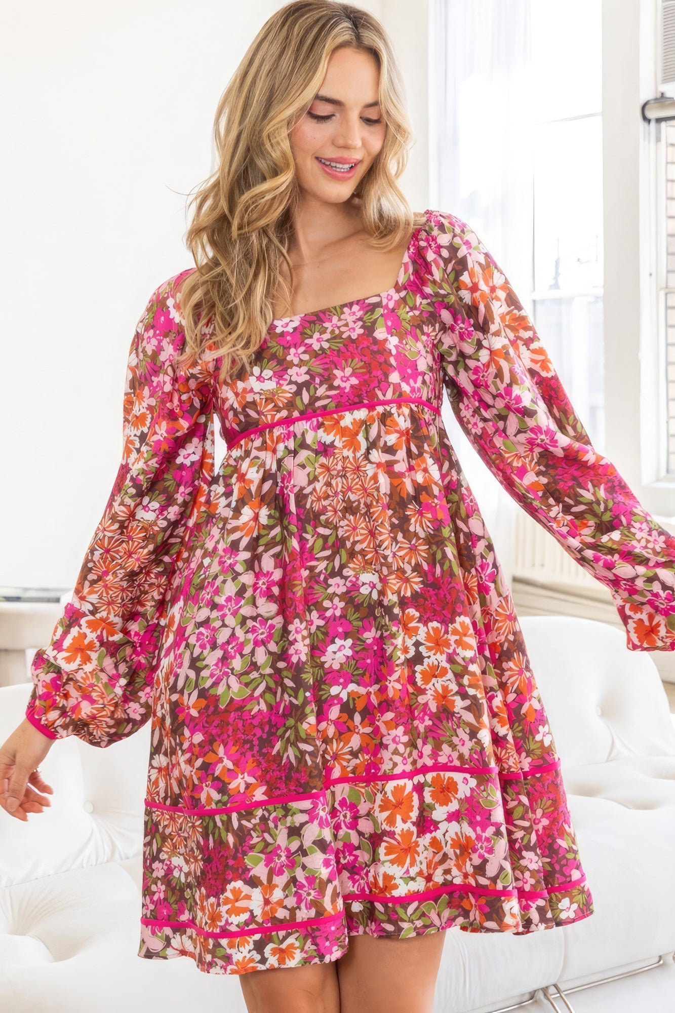 Introducing The Alyssa, a charming and stylish piece. This delightful dress features a square neckline, a tiered silhouette, and a captivating floral pattern in a rich dark pink hue. It has a smocked back bodice, long sleeves and functional side pockets. Immerse yourself in the luxurious blend of 75% rayon and 25% nylon, offering a lightweight and comfortable feel. Perfect for various occasions, this mini dress seamlessly transitions from casual outings to semi-formal events.