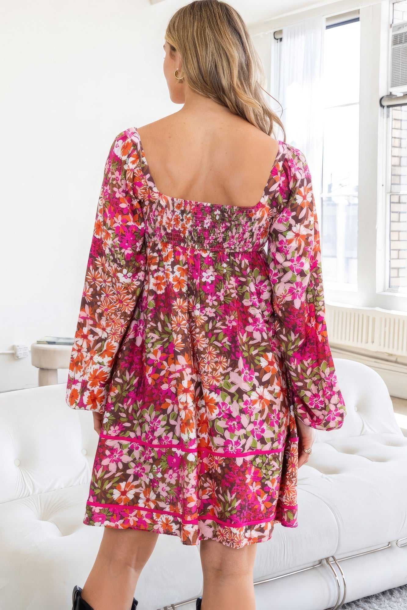Introducing The Alyssa, a charming and stylish piece. This delightful dress features a square neckline, a tiered silhouette, and a captivating floral pattern in a rich dark pink hue. It has a smocked back bodice, long sleeves and functional side pockets. Immerse yourself in the luxurious blend of 75% rayon and 25% nylon, offering a lightweight and comfortable feel. Perfect for various occasions, this mini dress seamlessly transitions from casual outings to semi-formal events.