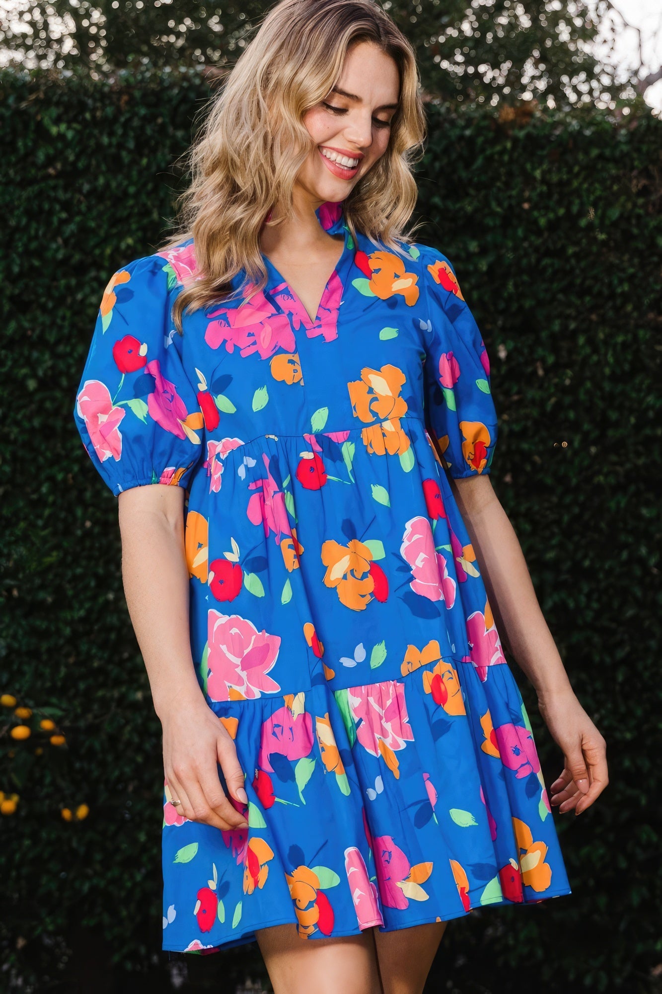 The Poppy is a charming royal blue dress that seamlessly combines style and comfort. It features a delightful floral print, complemented by a tiered silhouette, ruffle collar v-neck, and puff short sleeves for a playful yet chic look. Embrace the breathable blend of 97% Cotton and 3% Spandex that provides comfort and flexibility all day. Perfect for casual outings, brunches, or a day out with friends. Dress it up with accessories for a stylish evening look.