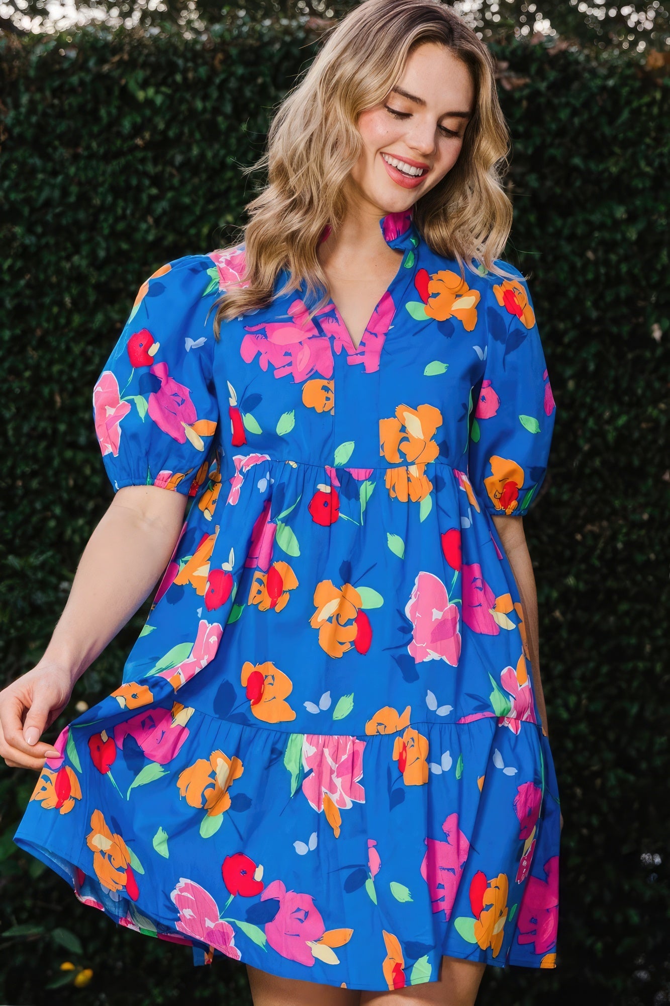 The Poppy is a charming royal blue dress that seamlessly combines style and comfort. It features a delightful floral print, complemented by a tiered silhouette, ruffle collar v-neck, and puff short sleeves for a playful yet chic look. Embrace the breathable blend of 97% Cotton and 3% Spandex that provides comfort and flexibility all day. Perfect for casual outings, brunches, or a day out with friends. Dress it up with accessories for a stylish evening look.