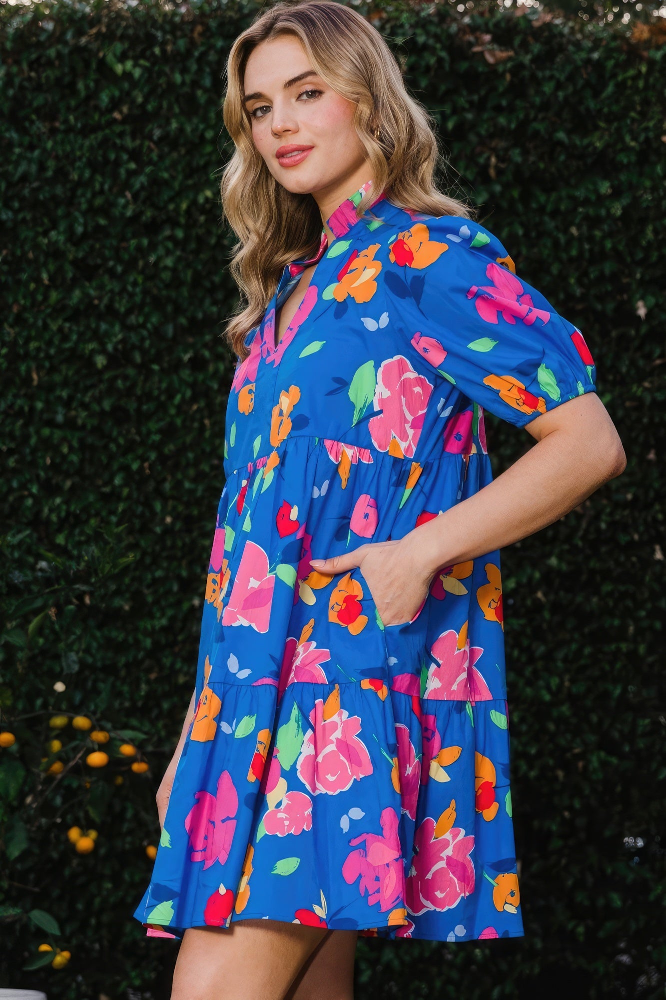 The Poppy is a charming royal blue dress that seamlessly combines style and comfort. It features a delightful floral print, complemented by a tiered silhouette, ruffle collar v-neck, and puff short sleeves for a playful yet chic look. Embrace the breathable blend of 97% Cotton and 3% Spandex that provides comfort and flexibility all day. Perfect for casual outings, brunches, or a day out with friends. Dress it up with accessories for a stylish evening look.
