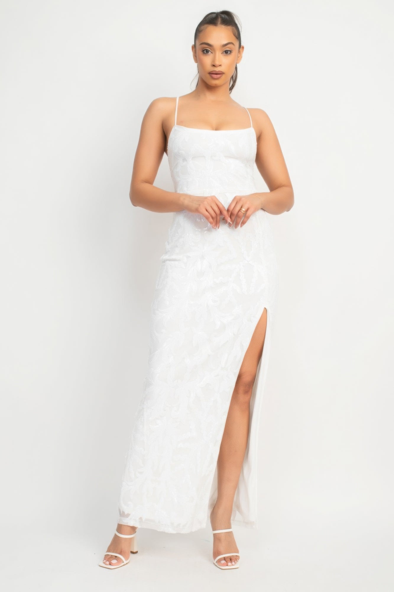 The Savannah is a glamorous addition to your wardrobe. This classic couture dress in Pure White is perfect for making a statement at any special occasion. Crafted from a luxurious blend of 90% polyester and 10% spandex, this dress offers both comfort and stretch. The sequin-studded design, scoop neckline, and bodycon silhouette accentuate your curves gracefully. With its back-crisscross tie design, side slit, and maxi-length, this dress exudes glamour from every angle.
