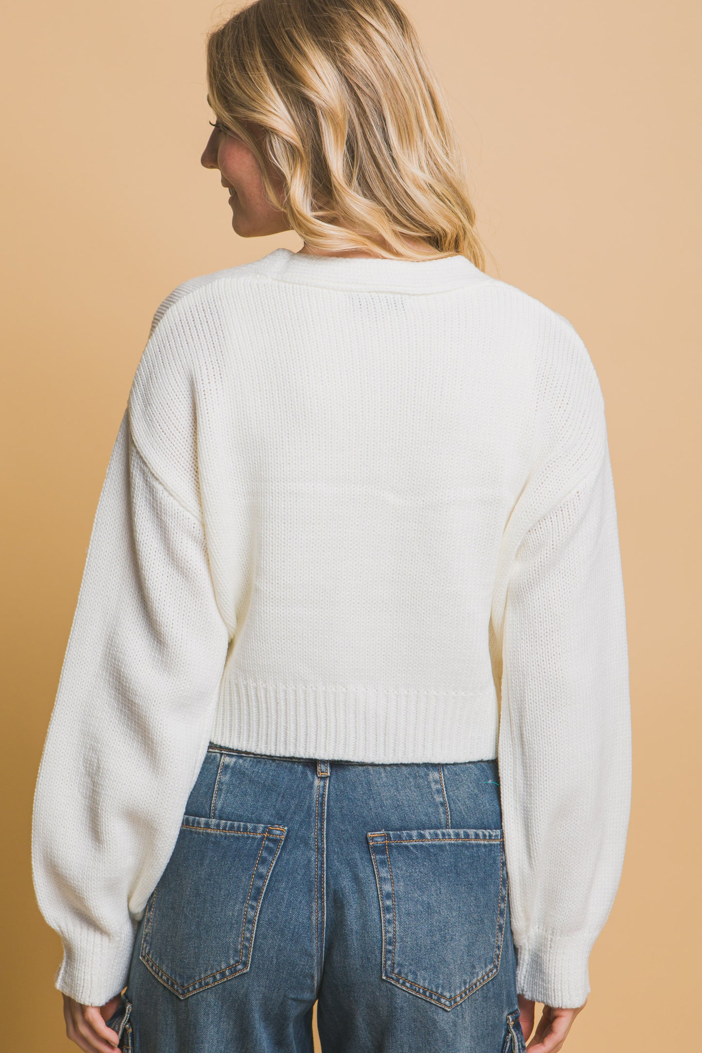 The Liya is a mid-cropped cardigan with charming flower details. Ideal for layering over dresses, blouses, or tees. Perfect for casual outings, work, or social events. Made from 100% acrylic. Colour: Off White.