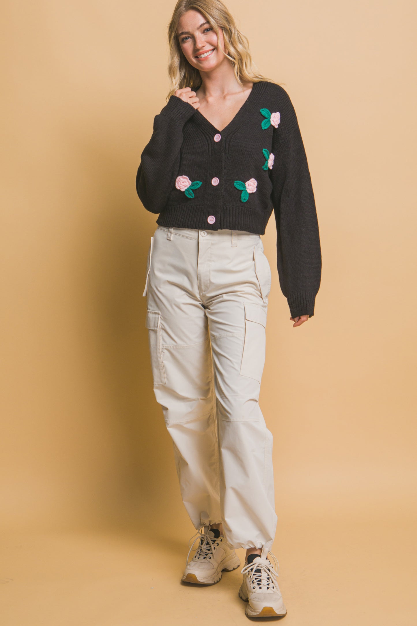 The Liya is a mid-cropped cardigan with charming flower details. Ideal for layering over dresses, blouses, or tees. Perfect for casual outings, work, or social events. Made from 100% acrylic. Colour: Black.