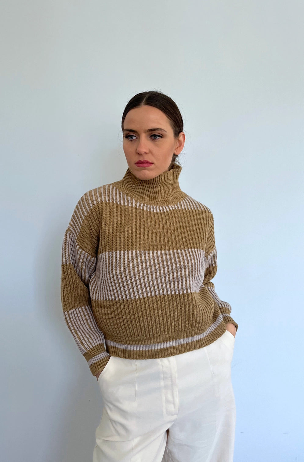 This soft-touch textured jumper is made of Merino Wool for extra comfort, warmth and coziness. It is designed with extra room around the chest for better movement and a high neck that gives it a classy touch. The colour is camel and white.
