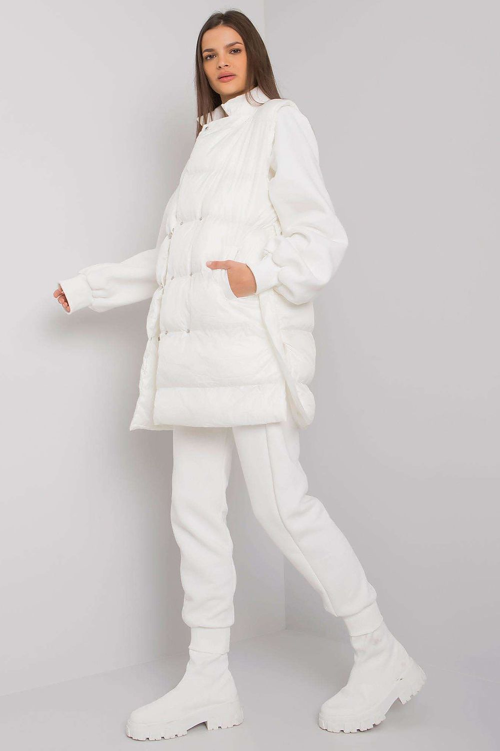 An interesting set consisting of a white down vest, a sweatshirt and sweatpants. The vest is fastened with press studs, on the sides there are slip pockets. Straight cut sweatshirt with long sleeves. Sweatpants with tie at waist and slant pockets.