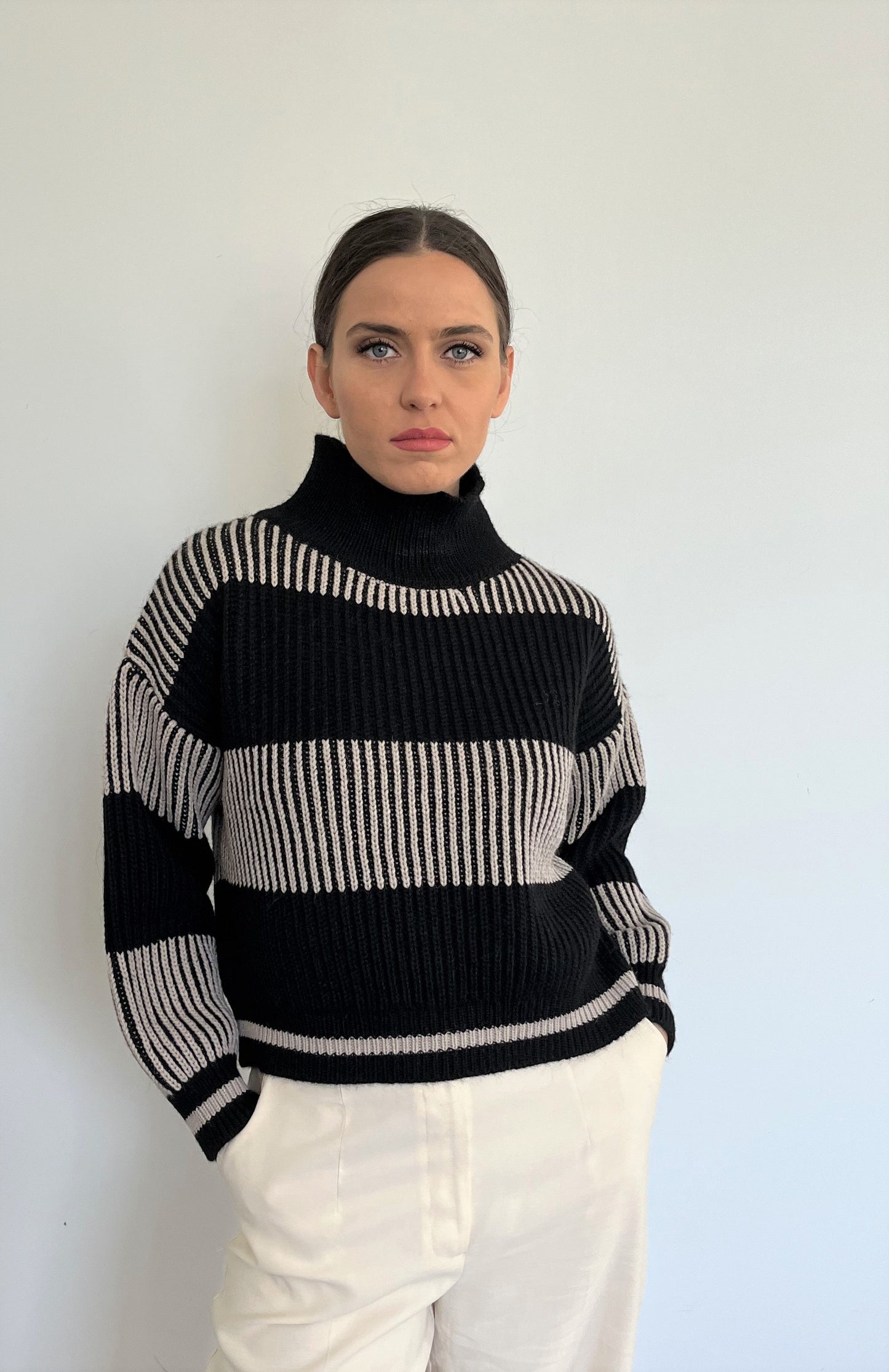 This soft-touch textured jumper is made of Merino Wool for extra comfort, warmth and coziness. It is designed with extra room around the chest for better movement and a high neck that gives it a classy touch. The colour is black and white.