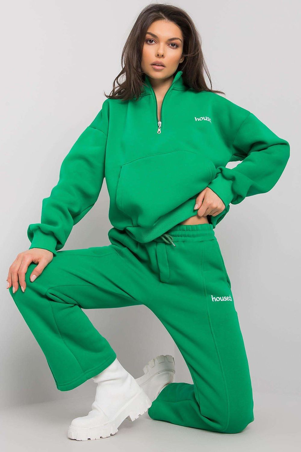 A set consisting of a green sweatshirt with long sleeves and a pocket on the front and green sweatpants with pockets and tie at waist.