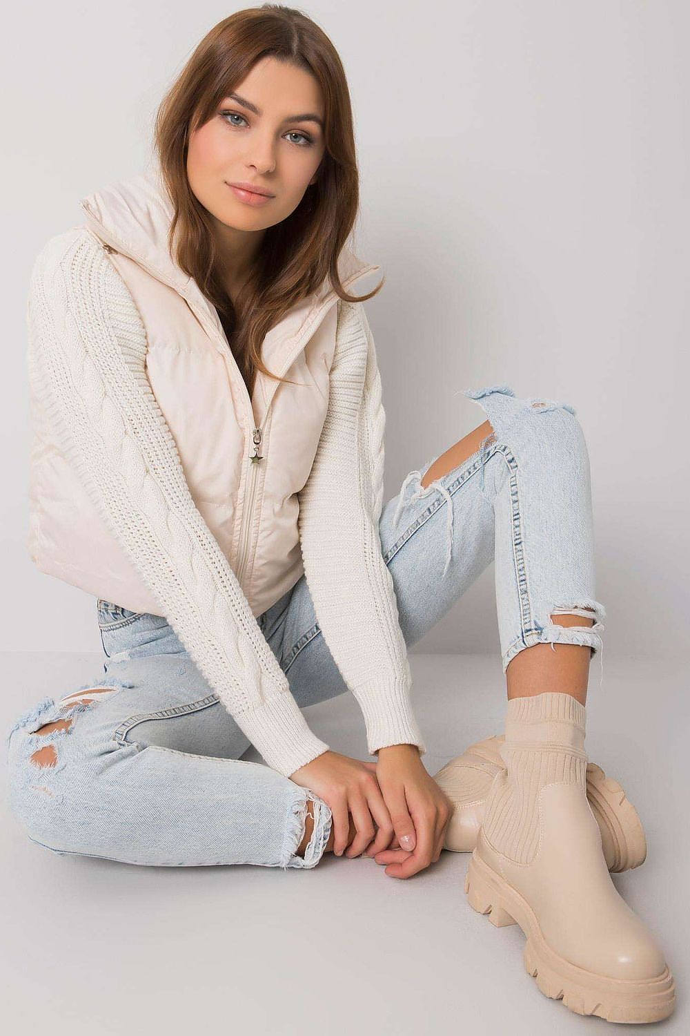 Zip fastened beige vest with a concealed hood.