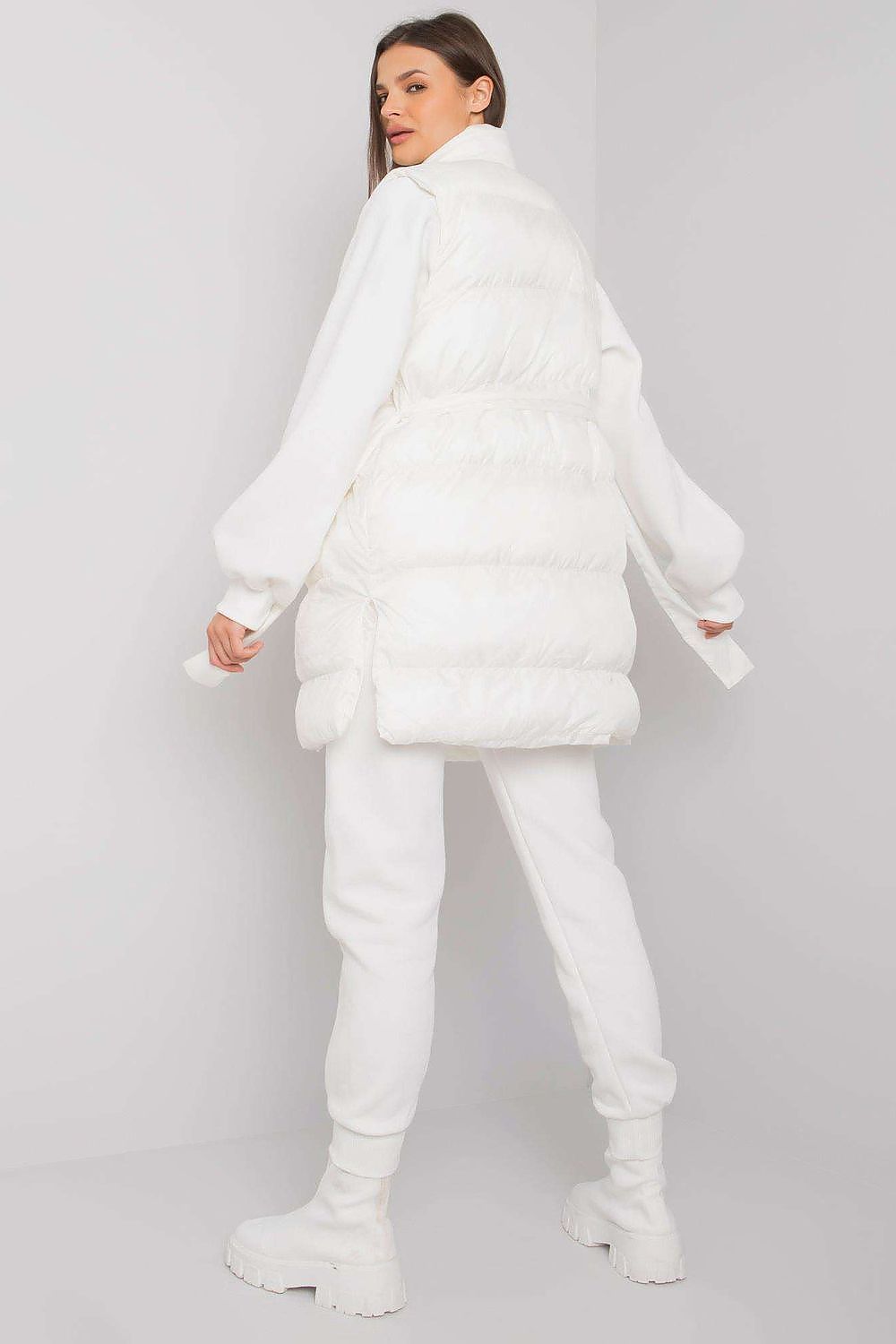 An interesting set consisting of a white down vest, a sweatshirt and sweatpants. The vest is fastened with press studs, on the sides there are slip pockets. Straight cut sweatshirt with long sleeves. Sweatpants with tie at waist and slant pockets.