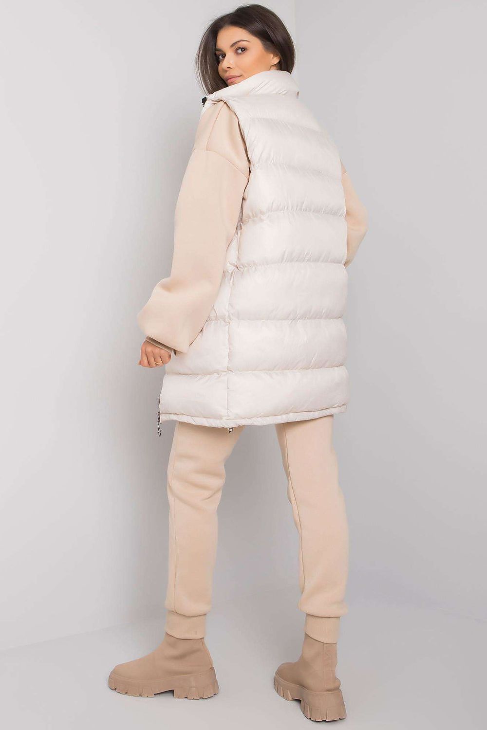 A set consisting of a beige sweatshirt and sweatpants and a white down vest. Zipped vest with pockets. Straight cut sweatshirt with long sleeves. Sweatpants with pockets and tie at the waist.