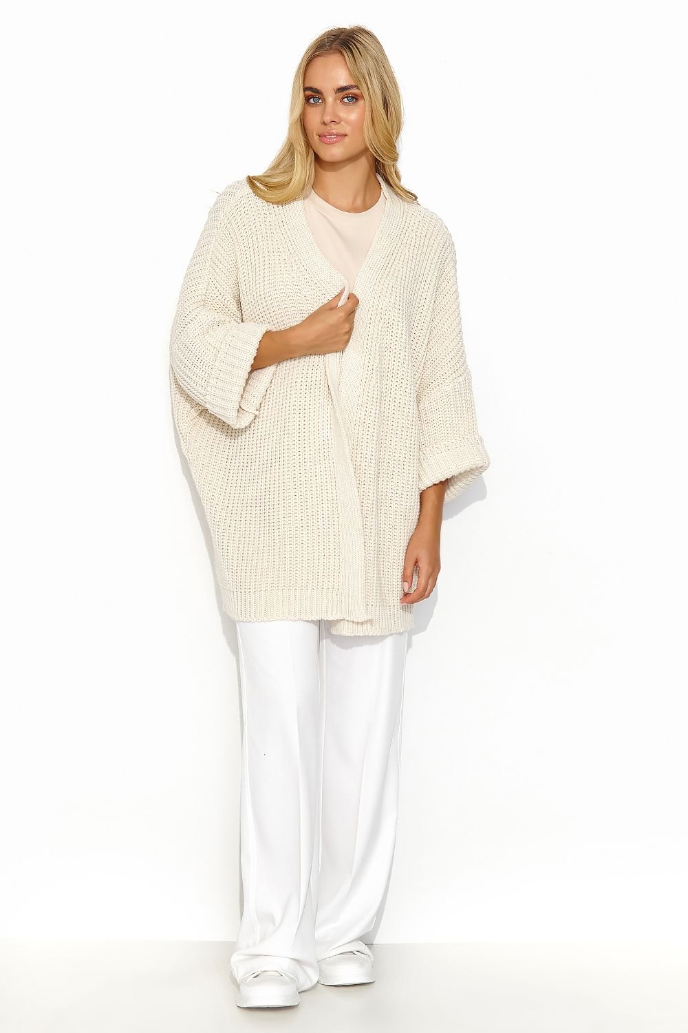 A cream buttonless cardigan with wide sleeves and a lot of character. This cardigan has a uniform and regular pattern. It looks great when paired with a dress or a simple t-shirt and jeans. It is a versatile piece that adds exceptional class to both casual and more formal outfits. Made in Europe.