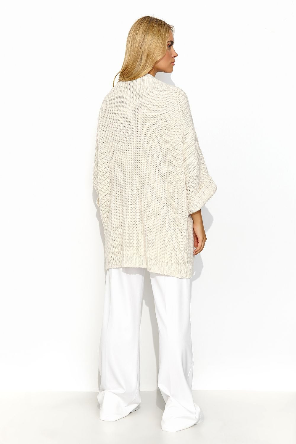 A cream buttonless cardigan with wide sleeves and a lot of character. This cardigan has a uniform and regular pattern. It looks great when paired with a dress or a simple t-shirt and jeans. It is a versatile piece that adds exceptional class to both casual and more formal outfits. Made in Europe.