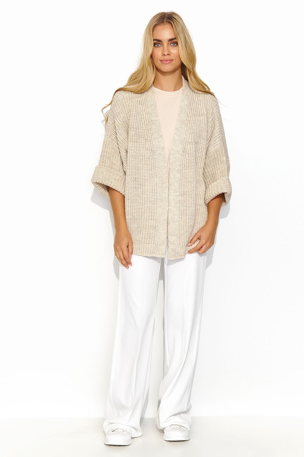 A beige buttonless cardigan with wide sleeves and a lot of character. This cardigan has a uniform and regular pattern. It looks great when paired with a dress or a simple t-shirt and jeans. It is a versatile piece that adds exceptional class to both casual and more formal outfits. Made in Europe.
