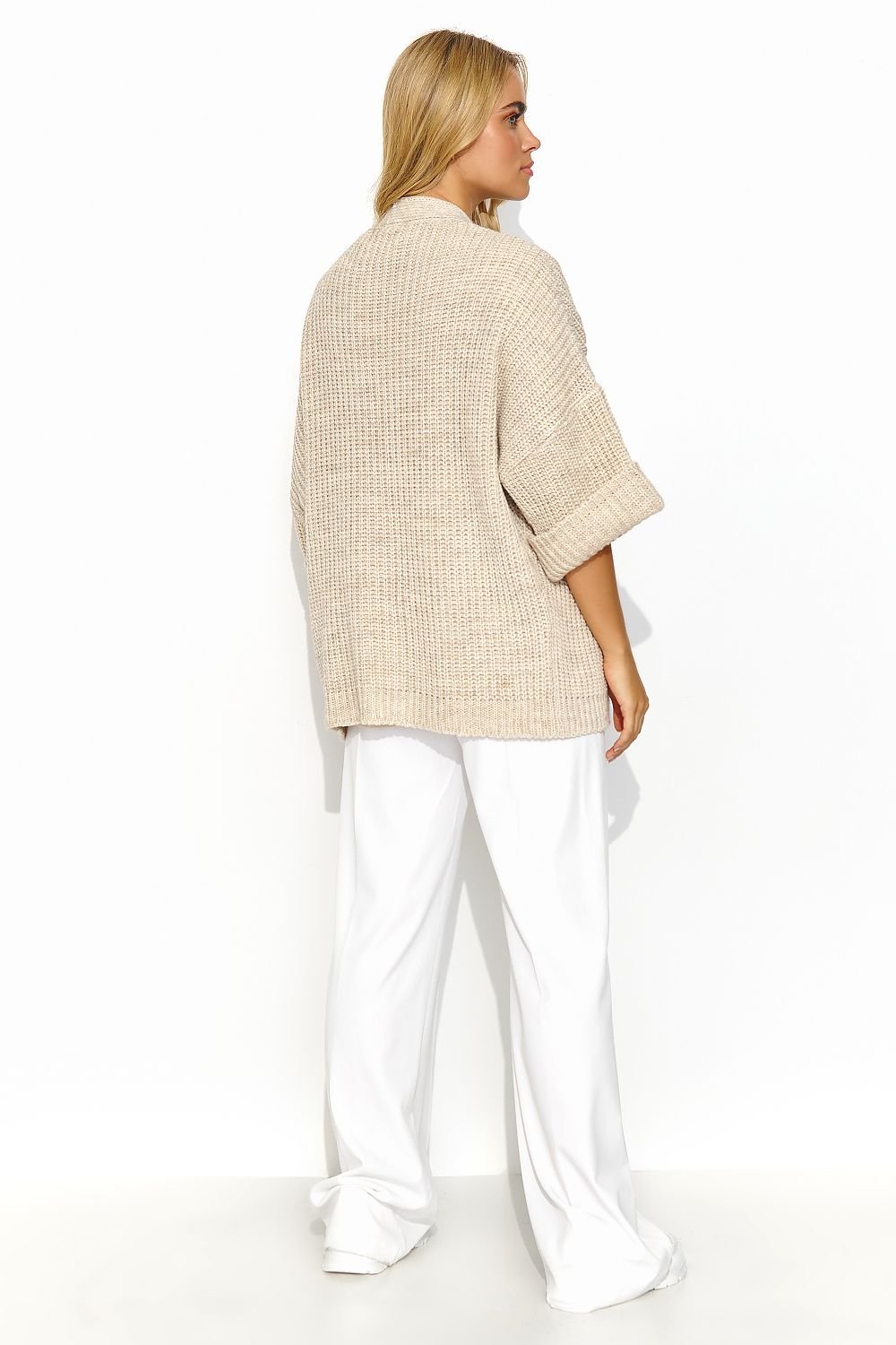 A beige buttonless cardigan with wide sleeves and a lot of character. This cardigan has a uniform and regular pattern. It looks great when paired with a dress or a simple t-shirt and jeans. It is a versatile piece that adds exceptional class to both casual and more formal outfits. Made in Europe.