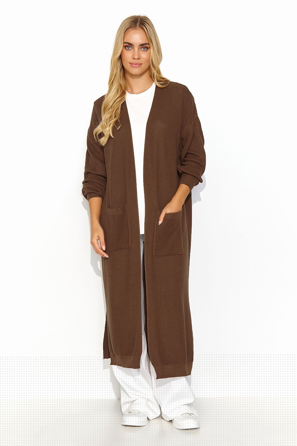 A long unbuttoned brown cardigan, straight cut with long sleeves and slits at the bottom. There are slip pockets on the front. A perfect choice for Spring and slightly colder days.