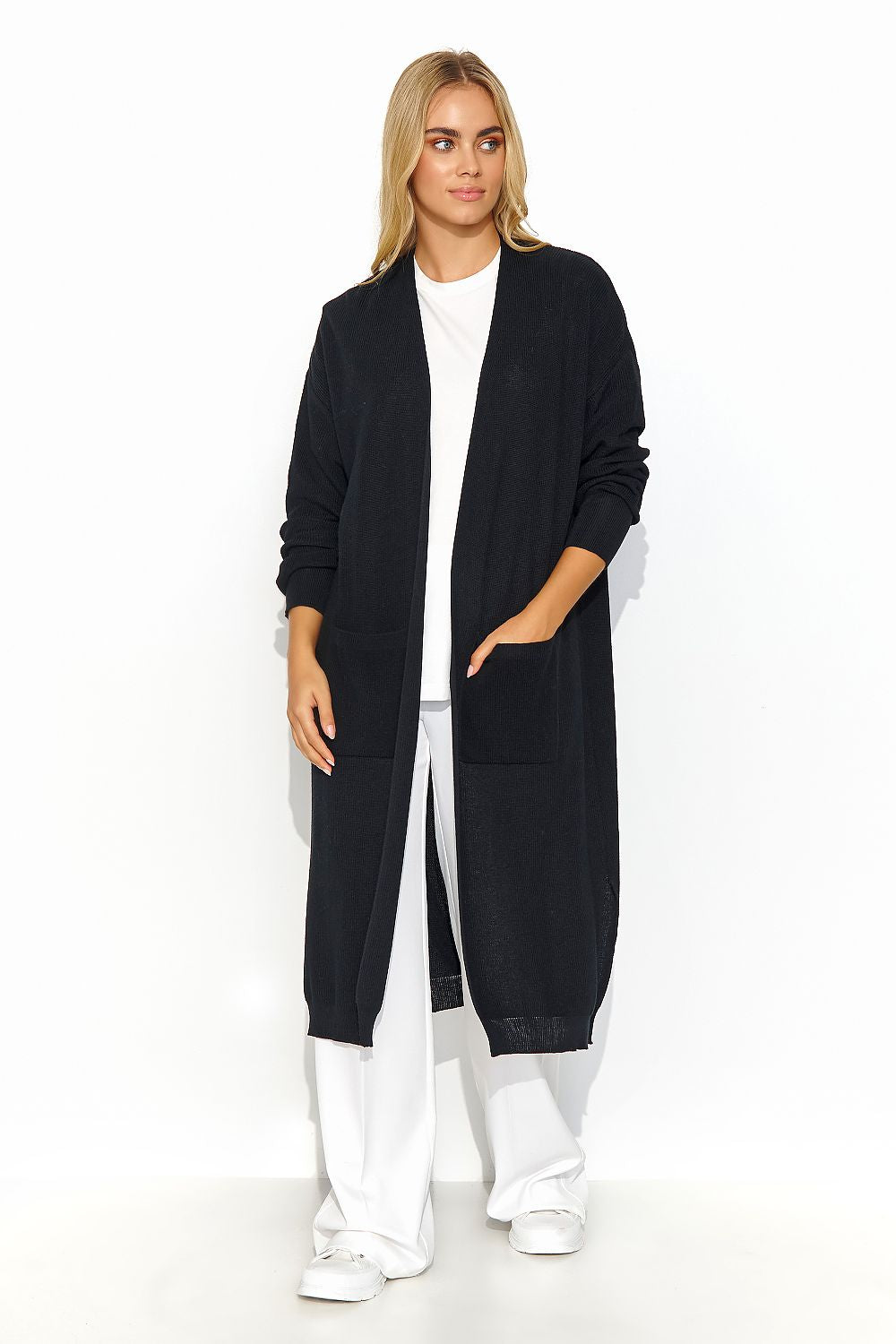 A long unbuttoned black cardigan, straight cut with long sleeves and slits at the bottom. There are slip pockets on the front. A perfect choice for Spring and slightly colder days.