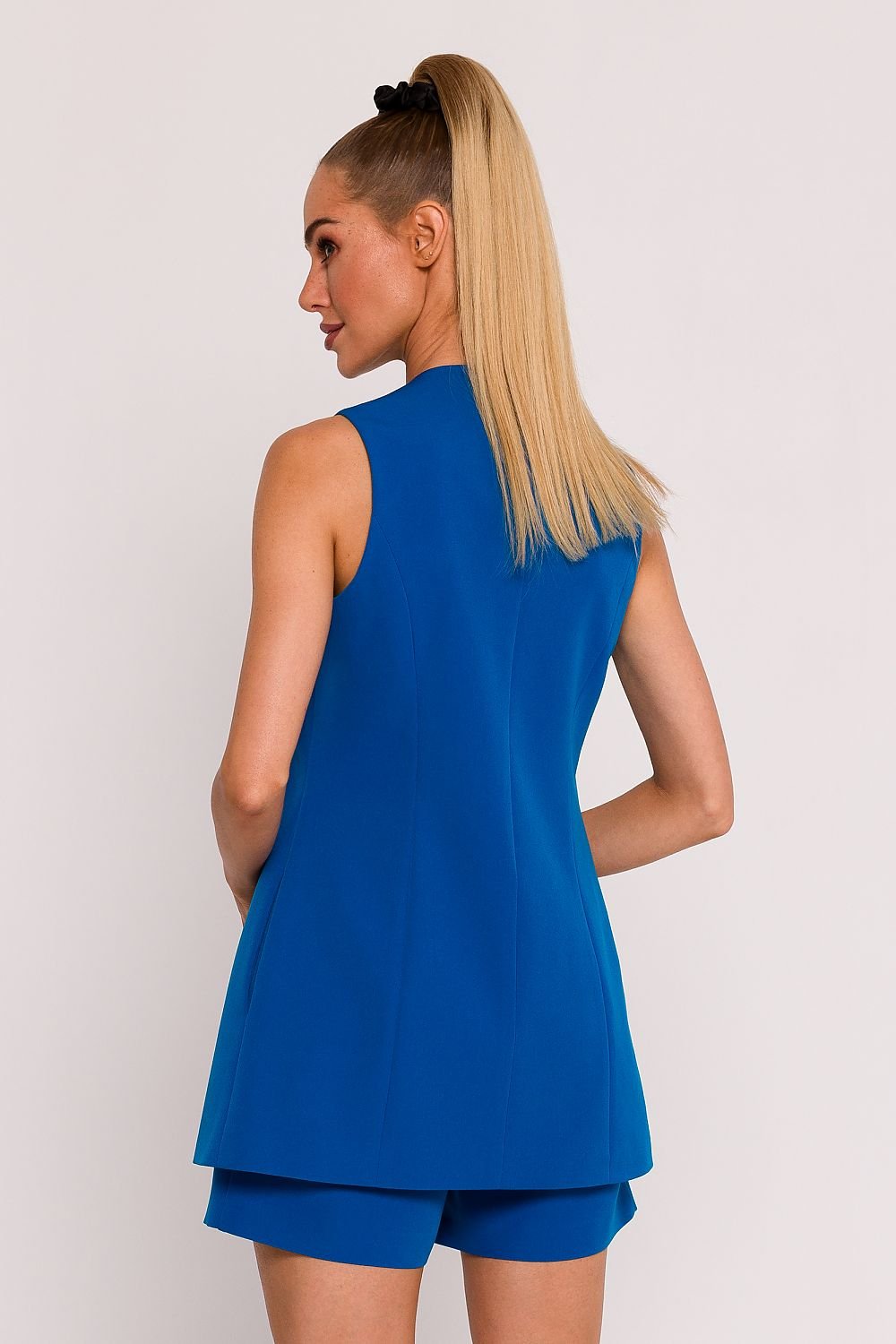 We present a unique fabric vest, designed and manufactured in Poland. The vest, fastened with a single button, looks exceptionally stylish and minimalist. The slightly waisted cut adds to its elegance. Collarless and with a deep V neckline, this vest looks modern and versatile. It has subtly hidden side seam pockets and is fully lined which makes the fabric fit perfectly on your body. Spandex 5% and Polyester 95%. Colour: Blue.