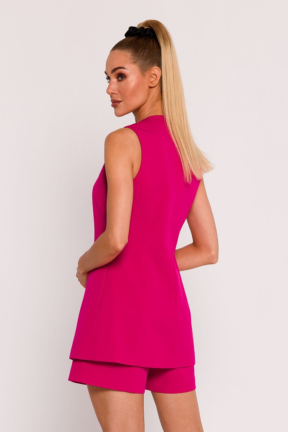 We present a unique fabric vest, designed and manufactured in Poland. The vest, fastened with a single button, looks exceptionally stylish and minimalist. The slightly waisted cut adds to its elegance. Collarless and with a deep V neckline, this vest looks modern and versatile. It has subtly hidden side seam pockets and is fully lined which makes the fabric fit perfectly on your body. Spandex 5% and Polyester 95%. Colour: Pink.