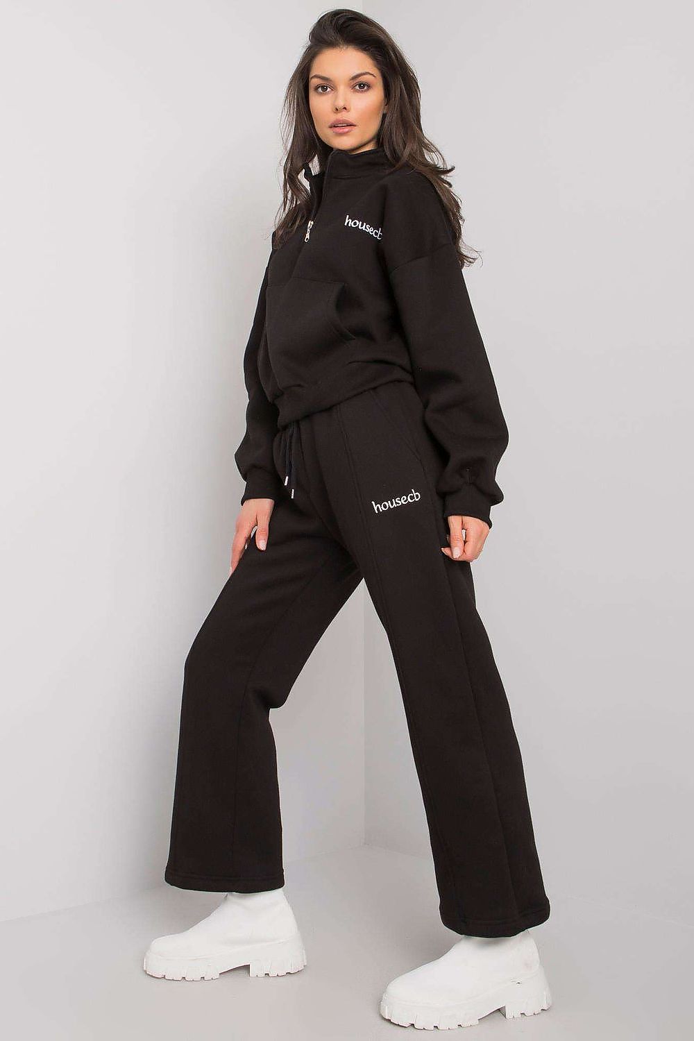 A set consisting of a black sweatshirt with long sleeves and a pocket on the front and black sweatpants with pockets and tie at waist.