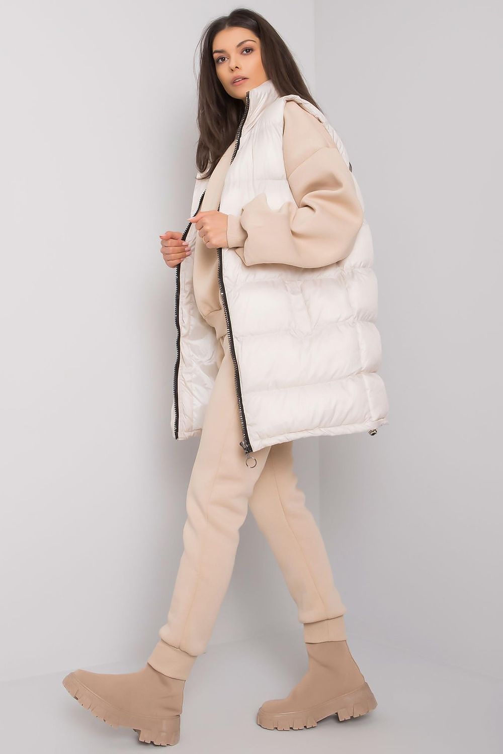 A set consisting of a beige sweatshirt and sweatpants and a white down vest. Zipped vest with pockets. Straight cut sweatshirt with long sleeves. Sweatpants with pockets and tie at the waist.