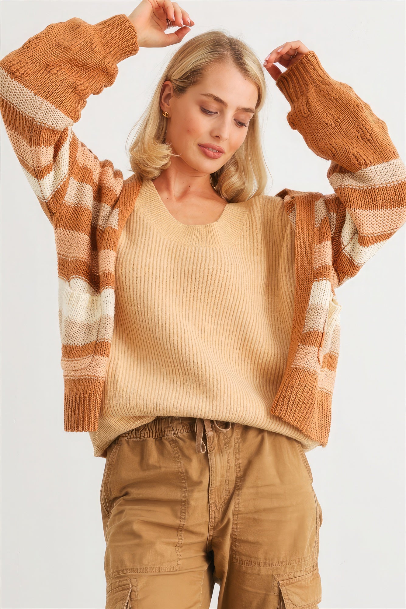 The Claire is camel our striped crochet knit cardigan. It features two pockets, a relaxed fit, dropped shoulders, and striped design for a casual stylish look. Perfect for casual outings and cozy evenings. Fabric: 90% Acrylic, 5% Polyester, and 5% Cotton.