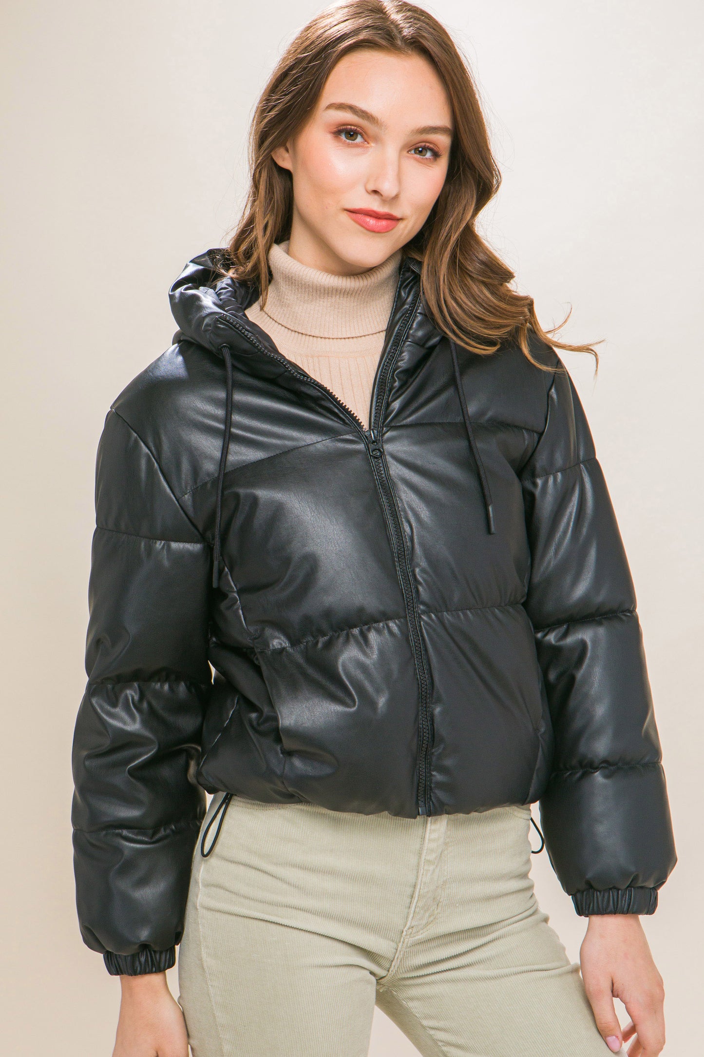 The Celine is our faux leather hooded puffer jacket. Tailored for maximum comfort, this jacket is perfect for all-day wear. Whether you're heading to a casual outing or for a night out downtown, this jacket is a versatile choice for any occasion. Fabric: Crafted from 100% Polyurethane Faux Leather. Colour: black.