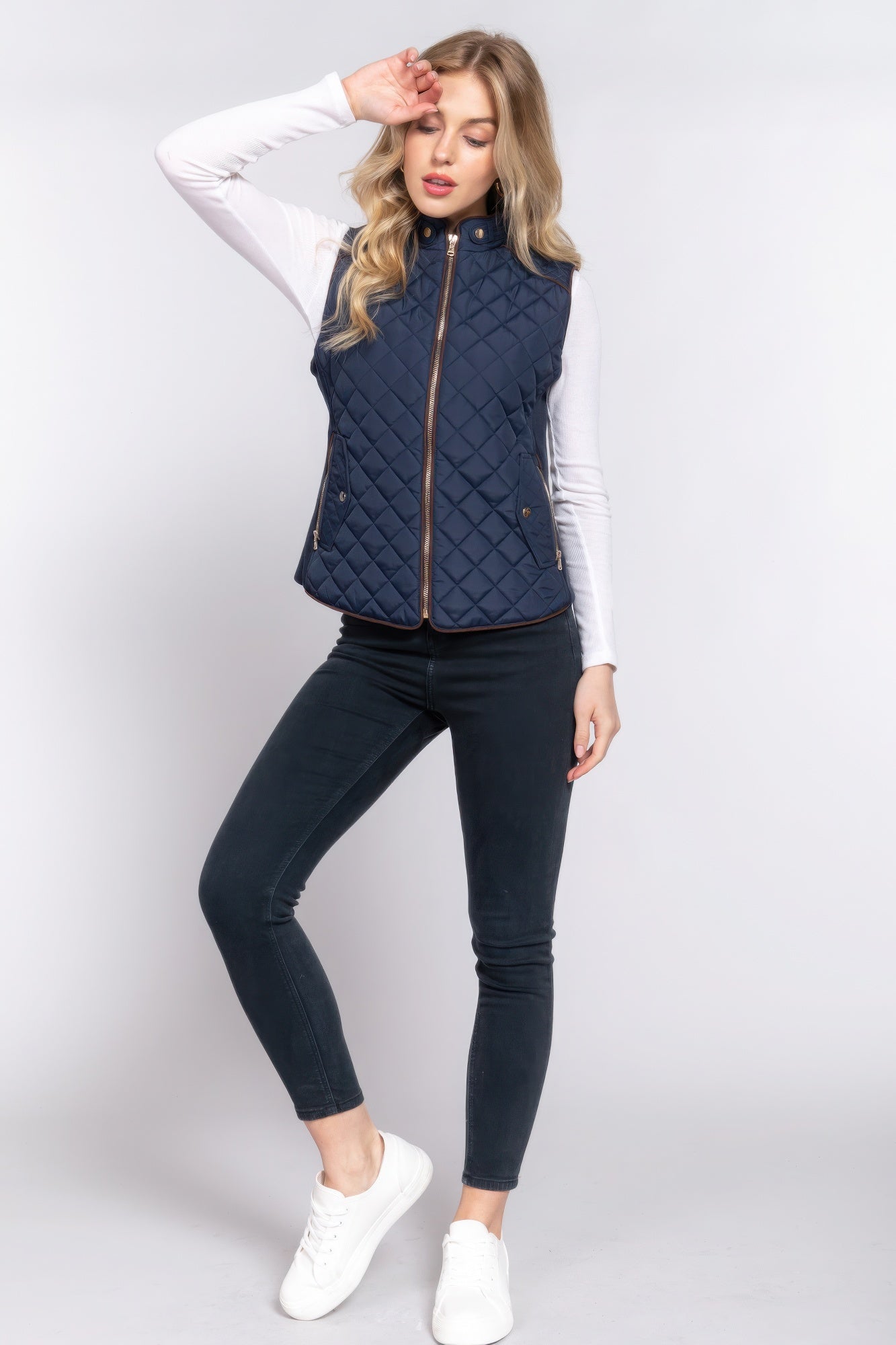 The Britney is our suede piping quilted padding vest. Crafted from 100% polyester, this vest is perfect for layering over sweaters or long sleeves. It features front pockets and side ribbing for added texture and style. Fabric: Made from 100% polyester. Colour: Navy.