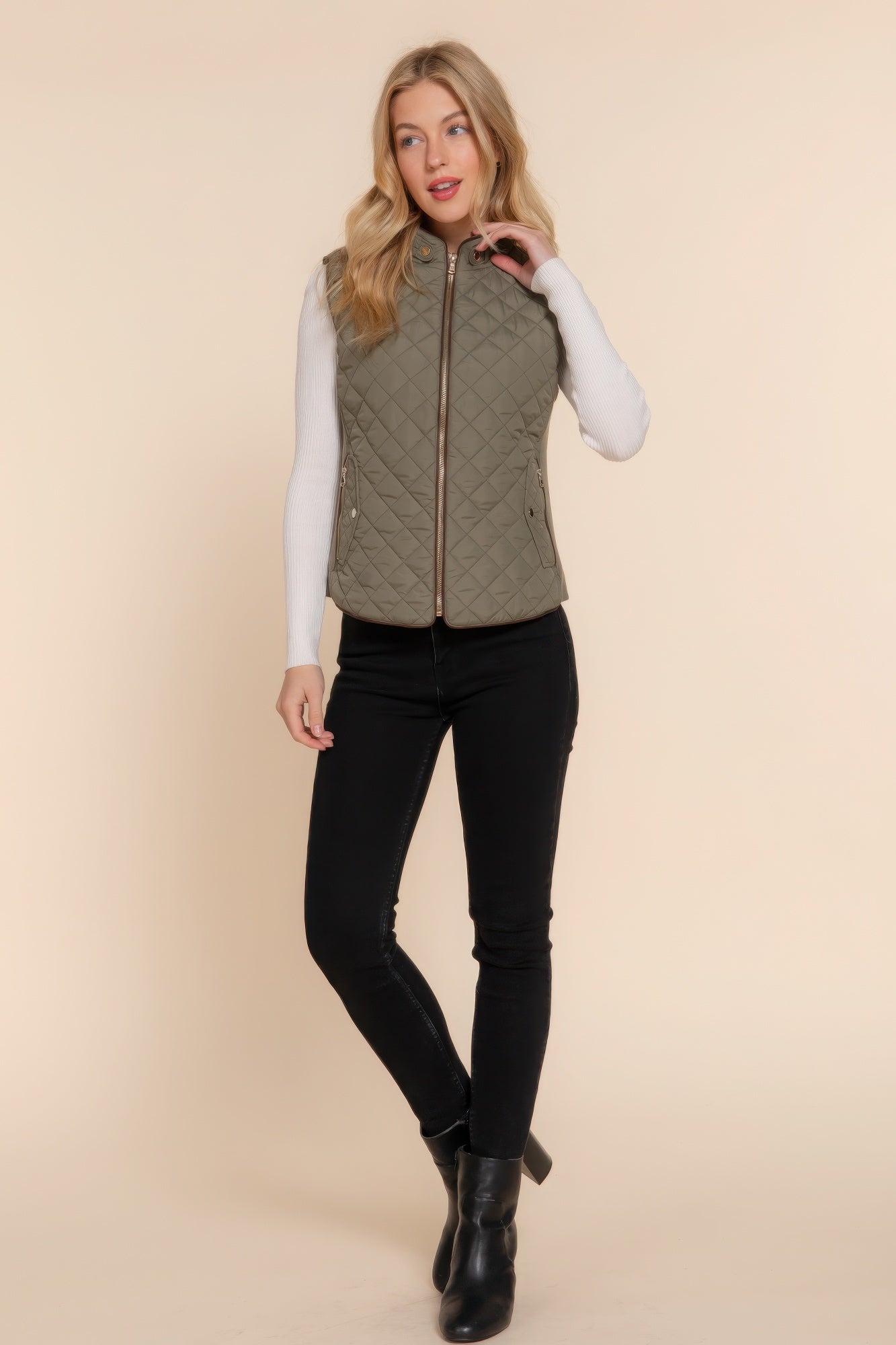 The Britney is our suede piping quilted padding vest. Crafted from 100% polyester, this vest is perfect for layering over sweaters or long sleeves. It features front pockets and side ribbing for added texture and style. Fabric: Made from 100% polyester. Colour: Olive.