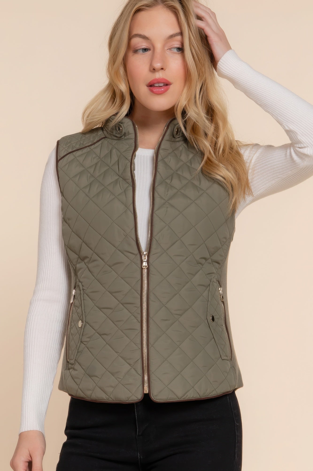 The Britney is our suede piping quilted padding vest. Crafted from 100% polyester, this vest is perfect for layering over sweaters or long sleeves. It features front pockets and side ribbing for added texture and style. Fabric: Made from 100% polyester. Colour: Olive.