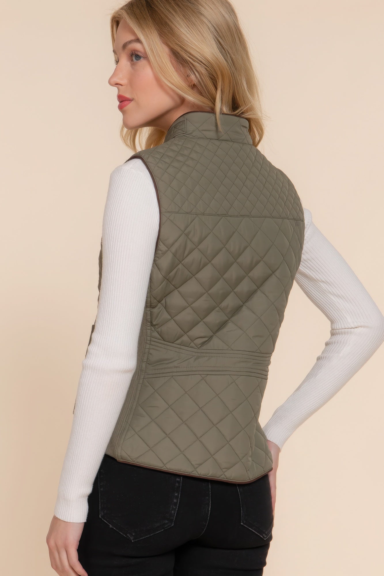 The Britney is our suede piping quilted padding vest. Crafted from 100% polyester, this vest is perfect for layering over sweaters or long sleeves. It features front pockets and side ribbing for added texture and style. Fabric: Made from 100% polyester. Colour: Olive.