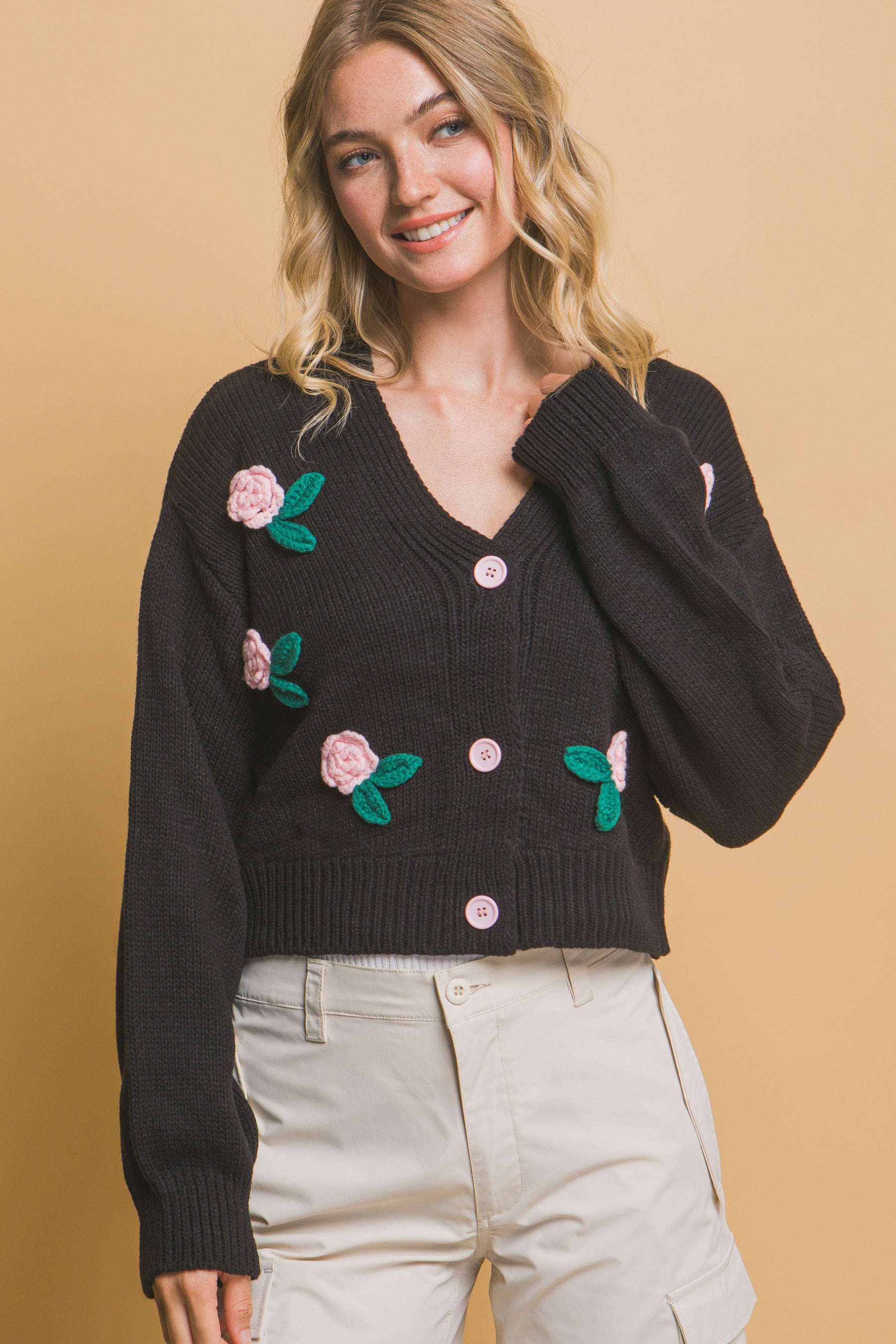 The Liya is a mid-cropped cardigan with charming flower details. Ideal for layering over dresses, blouses, or tees. Perfect for casual outings, work, or social events. Made from 100% acrylic. Colour: Black.