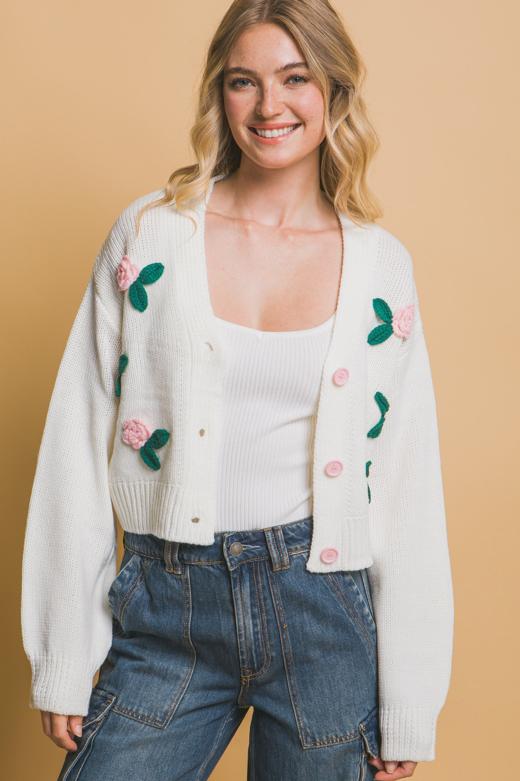 The Liya is a mid-cropped cardigan with charming flower details. Ideal for layering over dresses, blouses, or tees. Perfect for casual outings, work, or social events. Made from 100% acrylic. Colour: Off White.