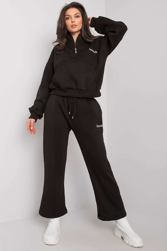 A set consisting of a black sweatshirt with long sleeves and a pocket on the front and black sweatpants with pockets and tie at waist.