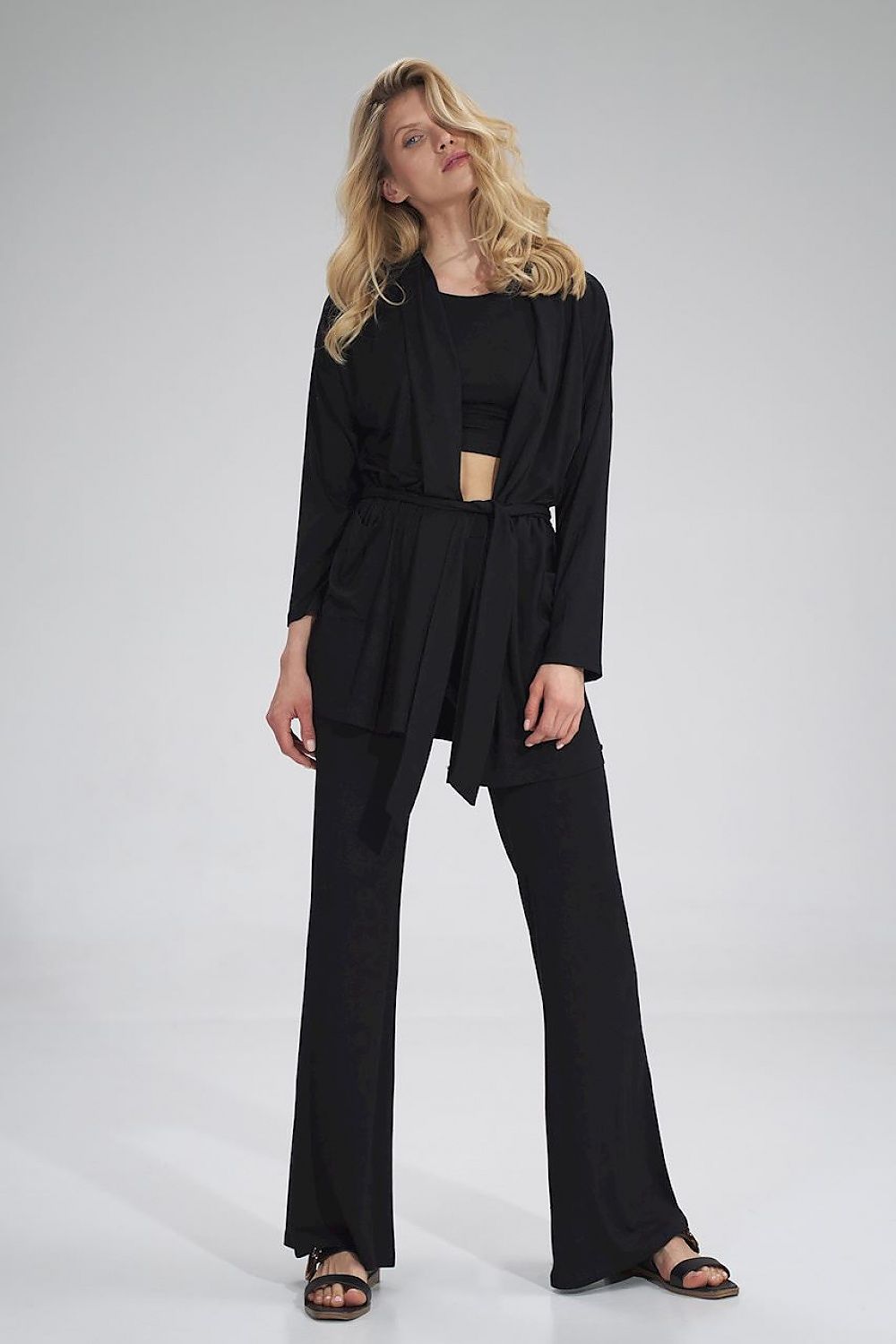 The Raven Pants is a black long bell-bottom pair of trousers with a wide elastic waistband, no pockets and no zipper. It goes hand in hand with The Raven Crop Top.