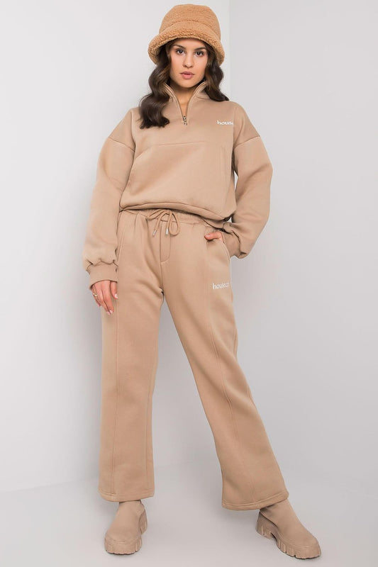 A set consisting of a beige sweatshirt with long sleeves and a pocket on the front and beige sweatpants with pockets and tie at waist.