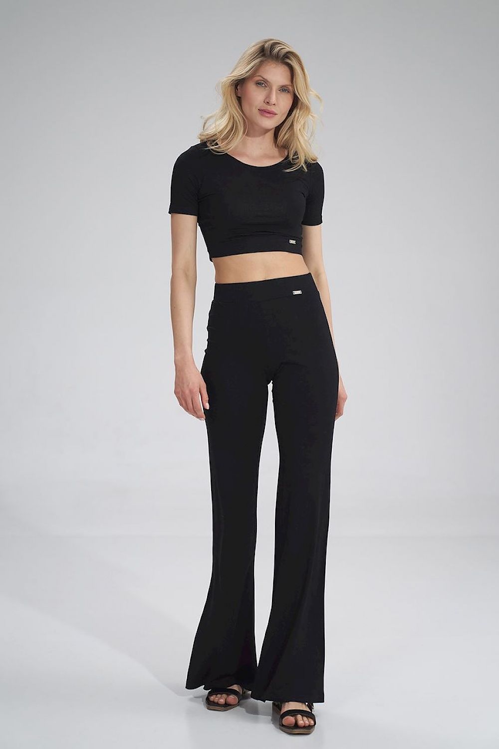 The Raven Crop Top is a black short-sleeve blouse, perfect for a small outing or working out. Pair it with The Raven Pants to create a stylish and trendy look.