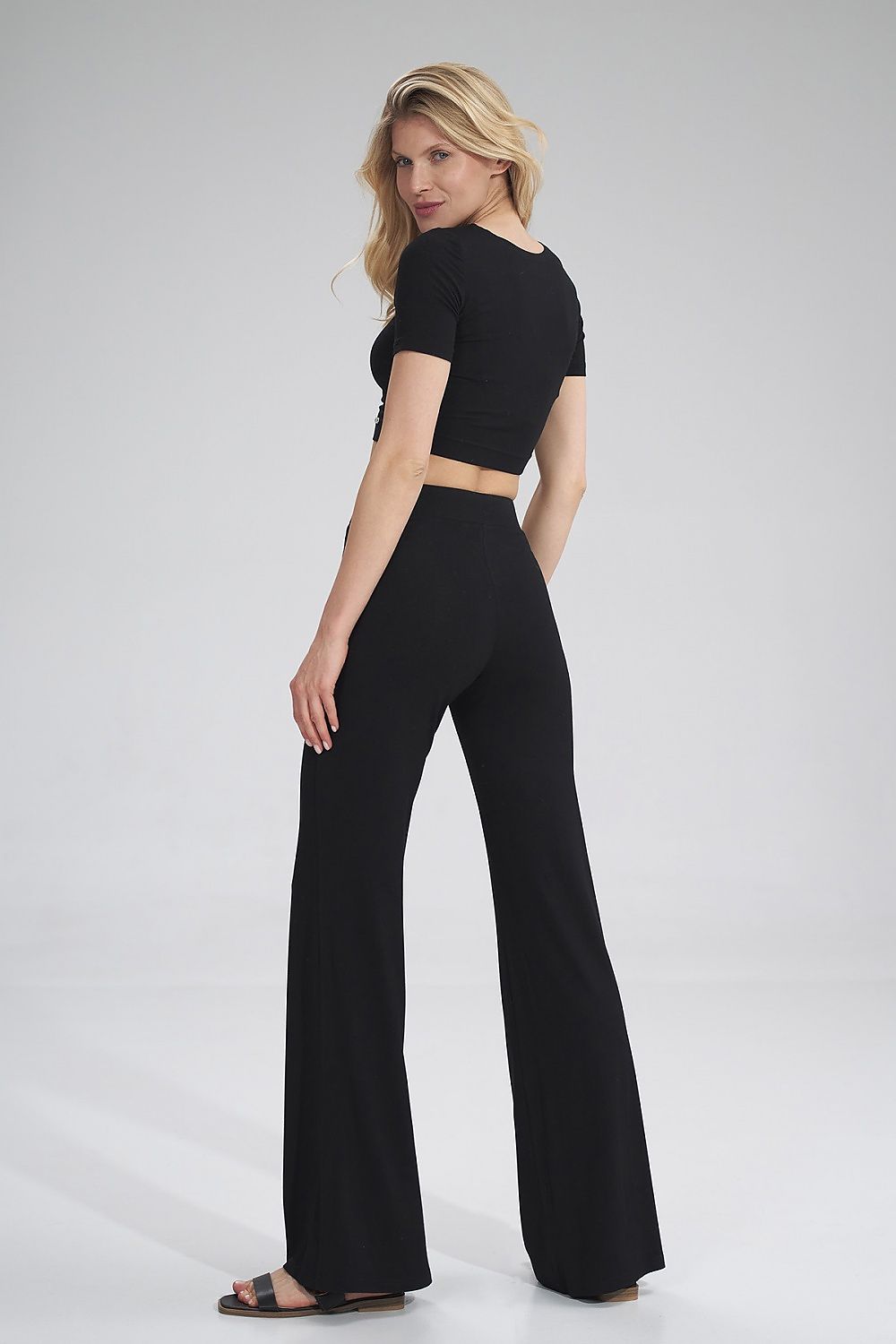 The Raven Crop Top is a black short-sleeve blouse, perfect for a small outing or working out. Pair it with The Raven Pants to create a stylish and trendy look.